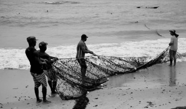 Salvador, Bahia, Brezilya - 18 Aralık 2020: balıkçılar Salvador şehrinde Pituba sahilindeki balıkçı teknesi boyunca balıkçılık yaparken görülürler.