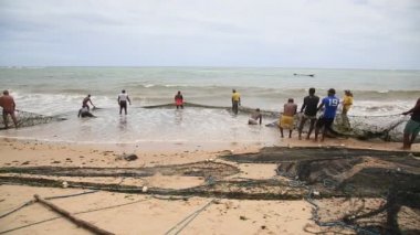 Salvador, Bahia, Brezilya - 18 Aralık 2020: balıkçılar Salvador şehrinde Pituba sahilindeki balıkçı teknesi boyunca balıkçılık yaparken görülürler..