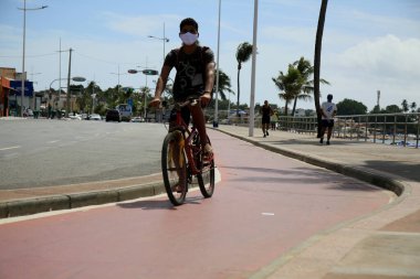 Salvador, Bahia, Brezilya - 21 Aralık 2020: Salvador 'un Itapua semtinde bisiklet süren bir bisikletçi görülüyor. * * * Yerel altyazı * *