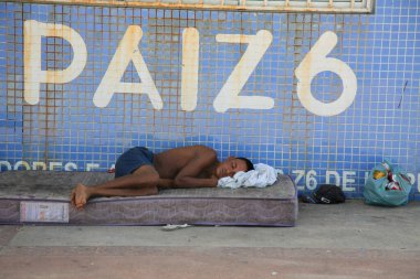 Salvador, Bahia, Brezilya - 21 Aralık 2020: Evsiz bir adam Salvador şehrindeki Z6 balıkçı kolonisinin yanında uyurken görüldü. * * * Yerel altyazı * *