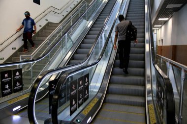 Salvador, Bahia, Brezilya - 23 Aralık 2020: Salvador şehrindeki havaalanında yürüyen merdiven kullanan kişi.