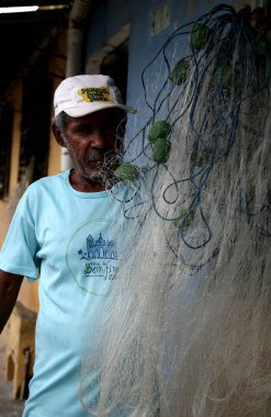 Mata de Sao Joao, Bahia, Brezilya - 1 Ekim 2020: balıkçı Mata de Sao Joao şehrinde balık ağını tamir ederken görüldü. * * * Yerel altyazı * *