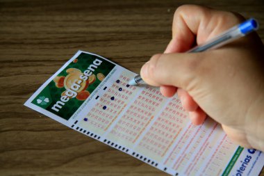 Salvador, Bahia, Brezilya - 2 Ocak 2021: Salvador şehrinde Mega Sena piyango bileti alan kişi.