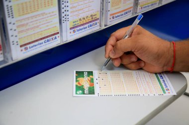 Salvador, Bahia, Brezilya - 25 Ocak 2021: Salvador şehrinde Mega Sena bahsini kura çekilişine koyan kişi görülüyor..
