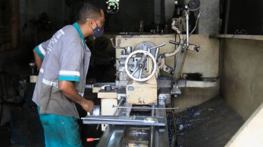 Salvador, Bahia, Brezilya - 27 Ocak 2021: İşçi, Salvador 'daki San Martin mahallesindeki bir endüstriyel öğütme atölyesinde görüldü..