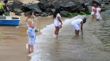 Salvador, Bahia, Brezilya - 2 Şubat 2021: Candomble dini üyeleri Salvador 'daki Rio Vermelho plajındaki orisha Yemanja' ya sunulan bir adak sırasında görülürler..