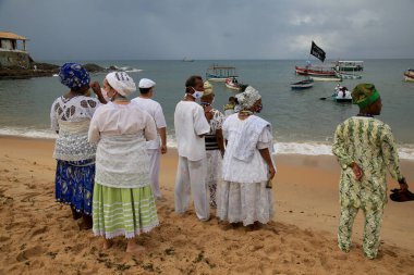 Salvador, Bahia, Brezilya - 2 Şubat 2021: Candomble dini üyeleri, Salvador 'daki Rio Vermelho plajındaki orisha Yemanja' ya sunulan bir adak sırasında görülürler..