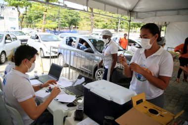 salvador, bahia, brazil - february 8, 2021: vaccination in the elderly over 90 years against covid-19, in the drive thru system, in a health center in the city of Salvador. clipart