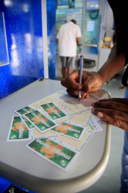 Salvador, Bahia, Brezilya - 15 Şubat 2021: Salvador şehir merkezindeki bir piyango acentesindeki müşteriler biriken Maga Sena 'ya bahis oynadılar..