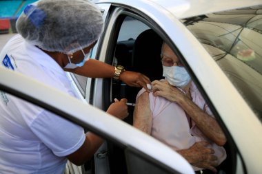 salvador, bahia, brazil - february 15, 2021: vaccination against the corona virus for elderly over 85 years old, in a drive thru system at Arena Fonte in the city of Salvador. clipart