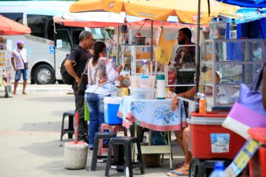 Salvador, Bahia, Brezilya - 17 Şubat 2021: satıcılar ve müşteriler Salvador 'daki Roman mahallesinde abur cubur ve yemek satan tezgahtarlarla karşı karşıya.