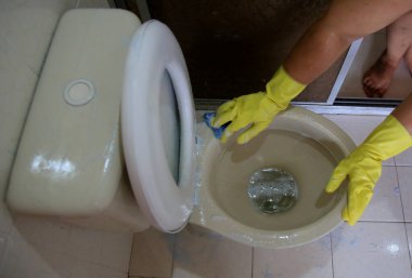 Salvador, Bahia, Brezilya - 21 Şubat 2021: Salvador şehrinde bir evin tuvaletini temizlerken lastik eldiven giyen kişi.