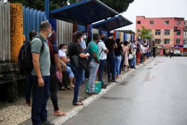 Salvador, bahia, brasil - 22 de junho de 2021: Yolcular grev nedeniyle Salvador 'un Cabula mahallesindeki bir otobüs durağında toplu taşıma beklerken görüldü..