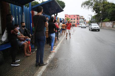 Salvador, bahia, brasil - 22 de junho de 2021: Yolcular grev nedeniyle Salvador 'un Cabula mahallesindeki bir otobüs durağında toplu taşıma beklerken görüldü..