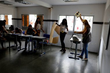 Salvador, Bahia, Brezilya - 7 Ekim 2018: Seçmenler Salvador 'daki seçimler sırasında bir sandık merkezinde hatalı elektronik oy kullanma makinelerini takas ederken görülüyor. * * * Yerel altyazı * * .