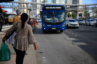 Salvador, Bahia, Brezilya - 20 Temmuz 2021: Yolcular Salvador şehrinde bir otobüs durağında toplu taşıma otobüslerini beklerken görüldü..