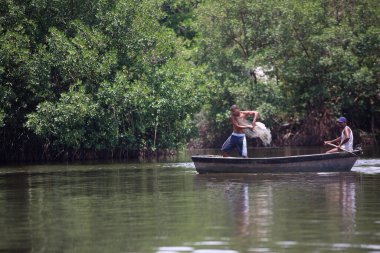 Lauro de freitas, Bahia, Brezilya - 20 Kasım 2017: Joanes nehrinin kirli sularında teknesi olan balıkçılar. Nehir, Salvador 'un metropolitan bölgesinden kanalizasyon suyu alır..