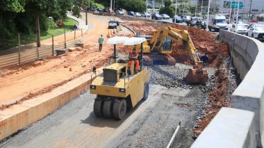 Salvador, Bahia, Brezilya - 10 Nisan 2024: Mekanizma Salvador şehrinde BRT sistemi için özel bir şerit inşa ederken görülüyor.