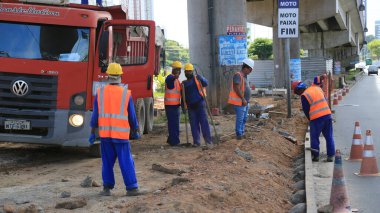 Salvador, Bahia, Brezilya - 16 Temmuz 2025: Salvador şehrinde bir geçiş yolu üzerinde çalışan inşaat işçileri.