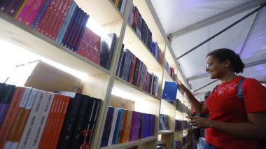 Şelale, Bahia, Brezilya - 23 Ekim 2025: Bir kişi Bahia 'daki Cachoeira Edebiyat Fuarı Flica' da bir kitap sergisinde toplandı.