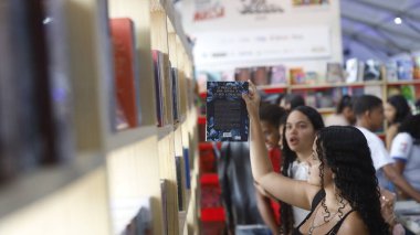Şelale, Bahia, Brezilya - 23 Ekim 2025: Bir kişi Bahia 'daki Cachoeira Edebiyat Fuarı Flica' da bir kitap sergisinde toplandı.