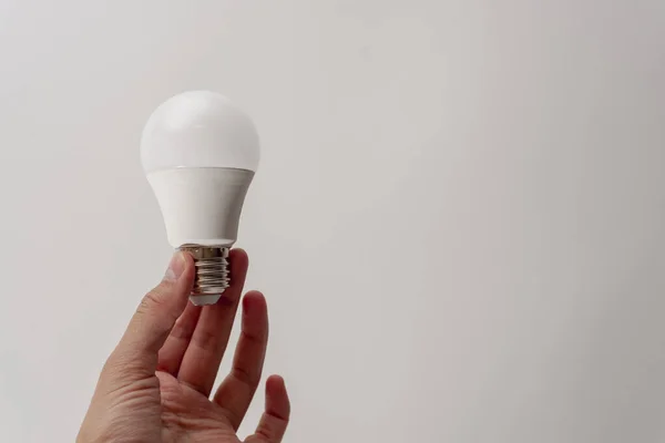 White LED light bulb in the hands of a man. The concept of ideas, thoughts.