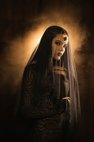 The beautiful girl with black hair in a black veil — Stock Photo, Image