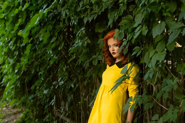 Belle fille rouge avec des lèvres rouges dans une robe jaune — Photo