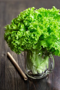 Salata yaprakları bir kavanozda, ahşap masada sağlıklı meyve suyu pişirmeye hazır. Yeşil vejetaryen çiğ yemek..