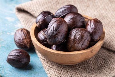 Mavi rustik ahşap masadaki çuval bezinde hindistan cevizi kabuğunun tamamı. Hint baharatı.