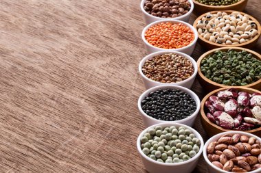 Tahta arka planda, telif uzayı olan çeşitli Hint baklagilleri. Sebze proteinleri. Vejetaryenler için protein ürünleri. Sağlıklı yeme kavramı.