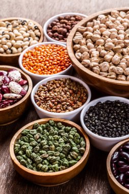 Ahşap arka planda çeşitli Hint baklagilleri var. Sebze proteinleri. Vejetaryenler için protein ürünleri. Sağlıklı yeme kavramı.