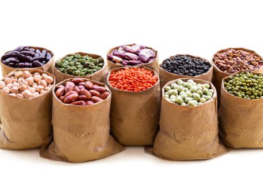 Telif uzayı beyaz arka planda izole edilmiş kese kâğıdında çeşitli Hint baklagilleri. Sebze proteini, vejetaryen yemeği, sağlıklı beslenme konsepti, tasarım..