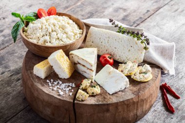 Kırsal ahşap masada çeşitli taze organik keçi peynirleri. Özel çiftliğin süt ürünleri. Ev yapımı peynir. Sağlıklı yemek, diyet..