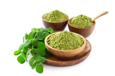 Moringa tozu (Moringa Oleifera) beyaz arka planda orijinal taze Moringa yapraklarıyla ahşap kaselerde bulunur. Sağlıklı ürün, süper yiyecek, vitamin.