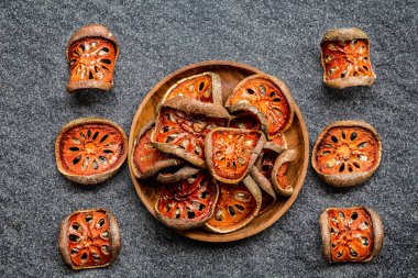 Kuru bael meyveleri (Aegle marmelos) matum (siyah arka planda ahşap kasede). Asya 'nın sağlıklı ürünü, Asya tedavisi bitkisel çay, vitamin, süper yiyecekler. Üst görünüm.