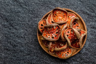 Kuru bael meyveleri (Aegle marmelos) matum (siyah arka planda ahşap kasede). Asya 'nın sağlıklı ürünü, Asya tedavisi bitkisel çay, vitamin, süper yiyecekler. Kopyalama alanı olan üst görünüm.  