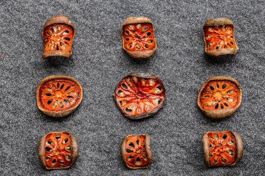 Kuru bael meyveleri (Aegle marmelos) matum (siyah arka planda ahşap kasede). Asya 'nın sağlıklı ürünü, Asya tedavisi bitkisel çay, vitamin, süper yiyecekler. Üst görünüm.