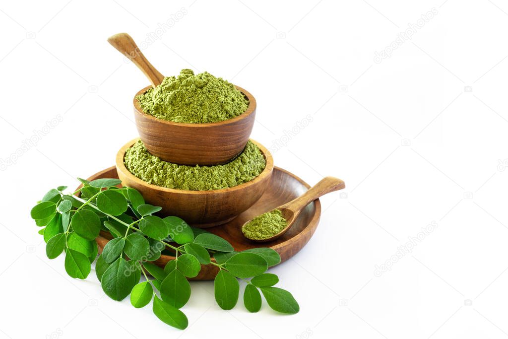 Moringa powder (Moringa Oleifera) in wooden bowl with original fresh Moringa leaves isolated on white background. Healthy product, superfood, vitamin.