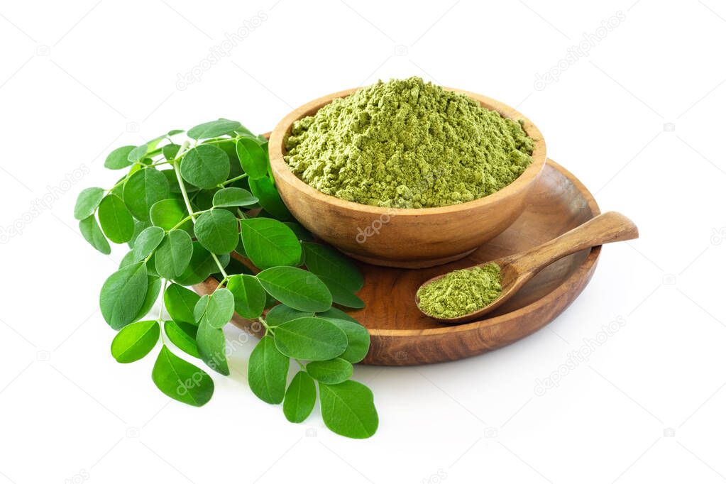 Moringa powder (Moringa Oleifera) in wooden bowl with original fresh Moringa leaves isolated on white background. Healthy product, superfood, vitamin.