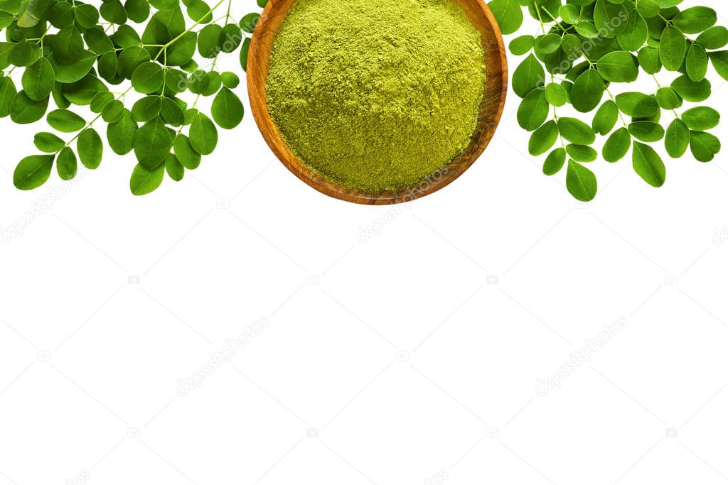 Moringa powder (Moringa Oleifera) in wooden bowl with original fresh Moringa leaves isolated on white background. Top view with copyspace. Healthy product, superfood, vitamin.