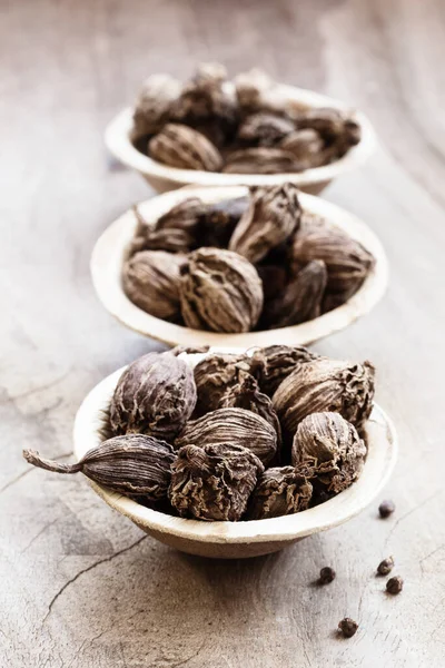 Semilla Entera Cardamomo Negro Tazón Coco Sobre Fondo Madera —  Fotos de Stock