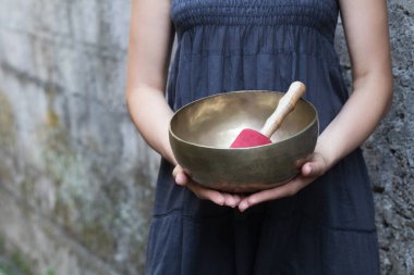 Büyük Tibet şarkı kasesi bir kadının elinde. Medetation yoga konsepti.