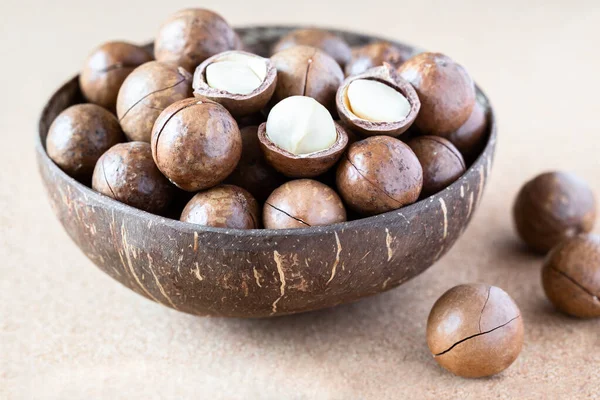 Nueces Macadamia Enteras Agrietadas Cuenco Coco Sobre Fondo Corcho —  Fotos de Stock