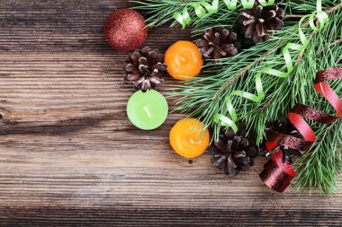 Noel süsü. Çam dalı, mumlar, koniler ve telif alanı, üst görünümü olan eski ahşap zeminde bir top.. 