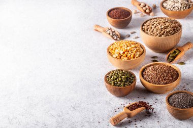 Fasulye çeşitleri, tohumlar, beyaz beton arka plandaki baklagiller. Sebze proteini kaynağı, sağlıklı beslenme..