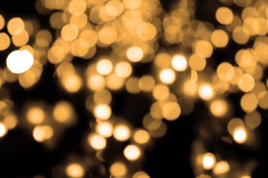 soyut olarak çözülmüş altın yuvarlak bokeh ya da turuncu ışık partisinden sıcak beyaz baloncuk sarı arka plan ve noel günü kutlaması ya da mutlu yeni yıl festivali için gece karanlığında