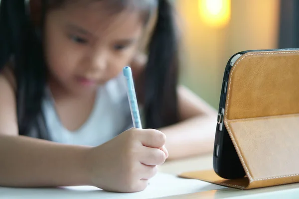 アジアの子供は学校や子供の女の子の笑顔に戻るノートを書くか コンピュータタブレット上で描画や新しいアイデアや人々がスマートフォンや暖かい白いランプでオンライン家庭学習から学ぶために宿題を行う — ストック写真