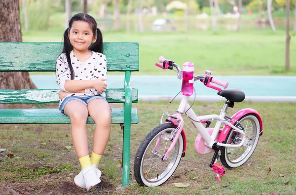 Niño Asiático Sonrisa Niña Sentarse Silla Larga Madera Con Bicicleta Imagen De Stock