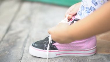 Çocukların elleri ya da kız çocuklarının öğrenme ve kravat bağlamayı deneyin. Pembe ayakkabı bağcıkları ya da spor ayakkabı ipleri ve ayakkabılar. Yürüyüş için.